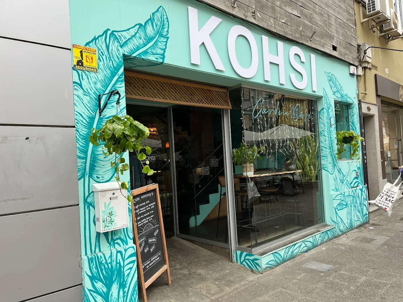 Fachada de Kohsi Garden Café con su mural verde en Castelldefels