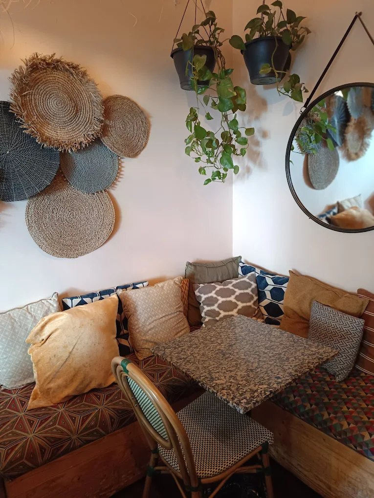 Rincón interior de Kohsi con cojines y plantas colgantes