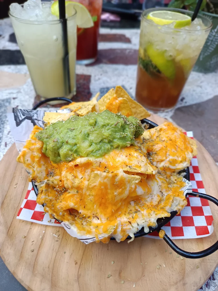 Nachos supreme de Kohsi con guacamole, queso fundido y cócteles